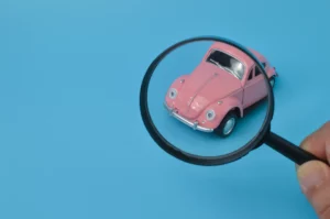 pink-retro-car-model-and-magnifying-glass-find